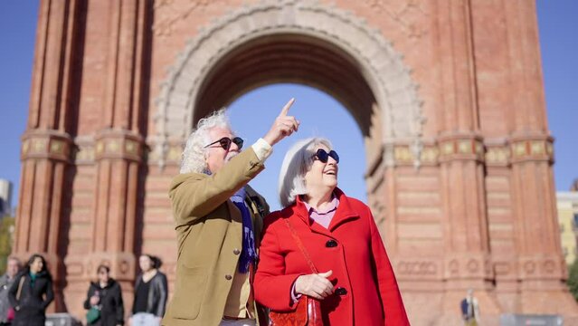 Video of modern senior tourist couple exploring the monuments of a city