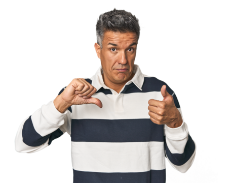 Middle-aged Latino man showing thumbs up and thumbs down, difficult choose concept