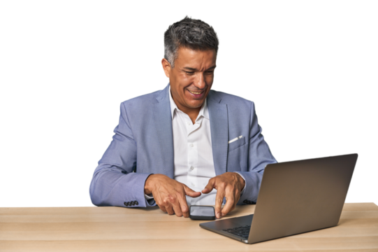 Celebratory middle-aged Hispanic man with laptop on phone call