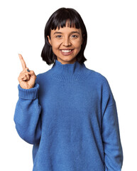 Young Hispanic woman with short black hair in studio showing number one with finger.