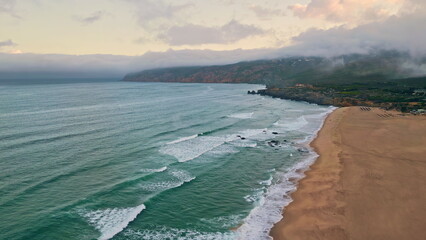 Stormy ocean surf foaming sand drone view. Sea water waves washing sandy beach