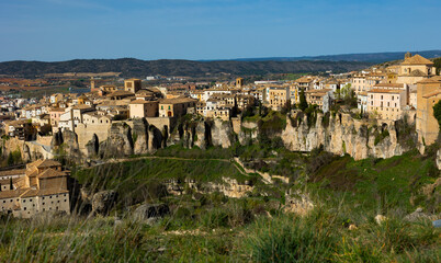 View of old part of Cuenca, medieval Spanish city on rocks with residential buildings hanging over abyss on sunny spring day ..
