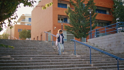 Tourist walking down stairs at evening sunlight. Woman exploring urban district