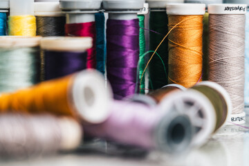 horizontal photo detail of colored bobbins for handmade sewing