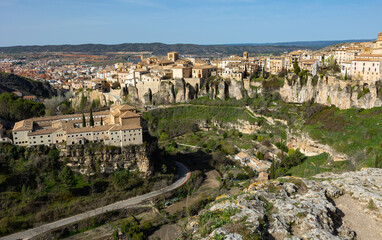 Fototapeta premium Scenic view of ancient Spanish city of Cuenca on sunny spring day overlooking convent of San Pablo located on rocky ledge above gorge with Huecar river in front of Hanging Houses..