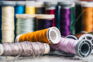 horizontal photo detail of colored bobbins for handmade sewing