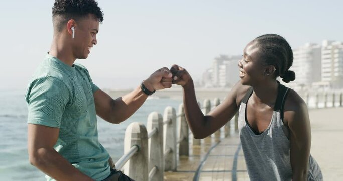 People, fist pump and fitness by beach for running, workout or outdoor exercise together in nature. Happy man and woman touching hands in start by ocean coast for teamwork, motivation or training