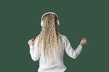 Modern stylish girl woman in headphones on head, listening to music and dancing, blonde long curly...