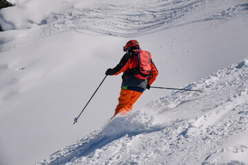 Dynamic photo of advanced skier downhill at the off piste area leaving fresh snow powder behind....