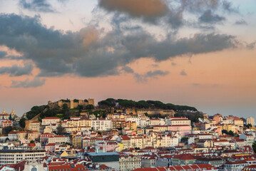 Cloudy golden hour sunset over Lisbon, Portugal cityscape with St. George Castle (Castelo de São...
