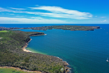 High angle aerial drone view of Grotto Point and Washaway Beach in the suburb of Clontarf, Sydney, New South Wales, Australia. Manly and North Head in the background.