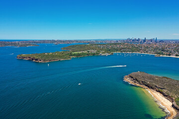 Fototapeta na wymiar High angle aerial drone view of Balmoral Beach and Edwards Beach in the suburb of Mosman, Sydney, New South Wales, Australia. CBD, North Sydney in the background, Grotto Point and Washaway Beach