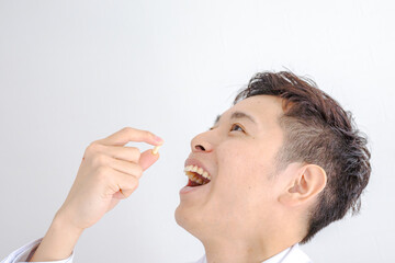 薬を飲む白衣の男性