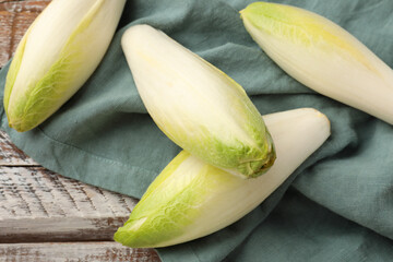 Fresh raw Belgian endives (chicory) on wooden table, top view - obrazy, fototapety, plakaty