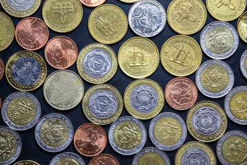 Argentine coins of different values on a dark background. In disuse due to uncontrolled monetary emission. Inflation.