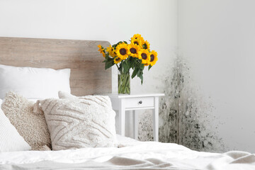Interior of light bedroom with bouquet of sunflowers on bedside table - obrazy, fototapety, plakaty
