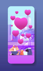 senior couple in love blowing bubbles and spending time with little dog in urban park valentines day celebration concept