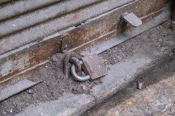 closed shop shutter. dirty, rusty and dusty padlock. economic crises and bankruptcies.