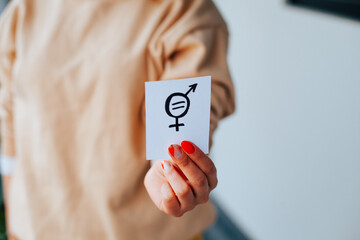 Photograph of incognito hands showing a message of equality.