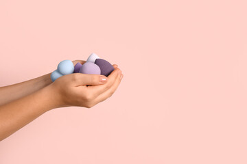 Female hands with different makeup sponges on pink background - obrazy, fototapety, plakaty