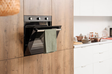 Wooden furniture with built-in oven in modern kitchen