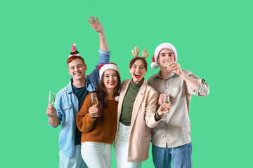 Group of friends with champagne on green background. New Year celebration
