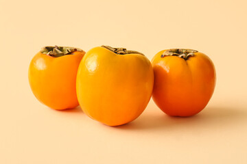 Sweet ripe persimmons on yellow background