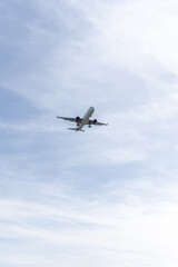 Fototapeta na wymiar Fuselage of a passenger plane in a beautiful blue sky descending towards the runway of Madrid airport