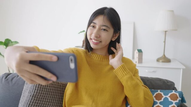 Asian girl selfie with smartphone, using mobile at home morning 