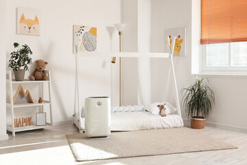 Interior of children's room with air purifier and bed