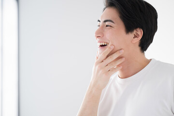 Asian (Japanese) man touching cheek Fresh image of hair removal and skin care Close-up