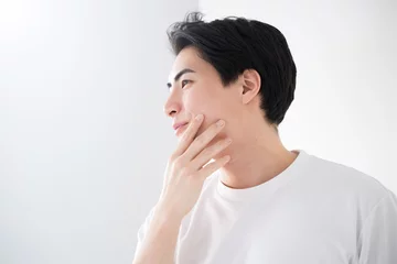 Fotobehang 頬を触るアジア系（日本人）男性 爽やかな脱毛やスキンケアのイメージ クローズアップ メンズの美容やビューティーに © kapinon