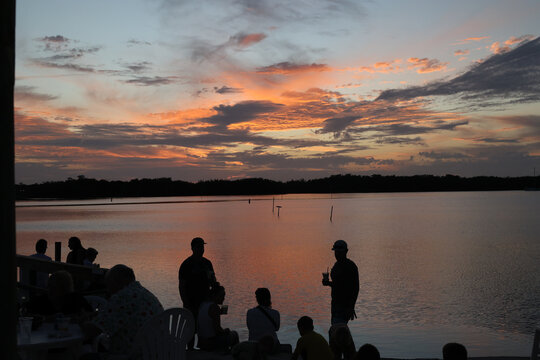 People chilling at seaside with beautiful sunset sky view