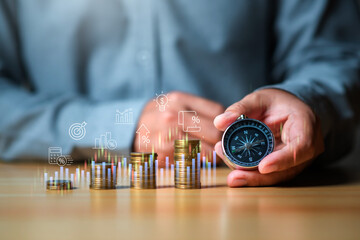 Financial planning and anlysis concept, Businessman holding compass with coinstack and financial...