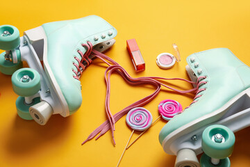 Composition with pair of vintage roller skates and cosmetic products on orange background, closeup