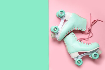 Pair of blue vintage roller skates on color background
