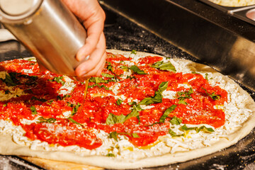 Drizzling oil on a pizza