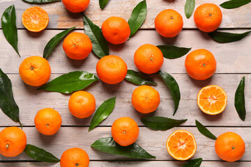 Sweet mandarins and leaves on grey wooden background