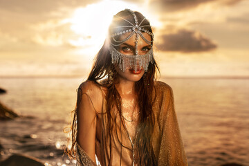 beautiful young tribal style woman outdoors at golden sunset - 716117380