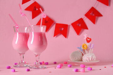 Glasses of tasty cocktail with candies and zephyr on pink background. Valentine's Day celebration