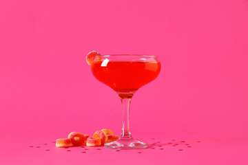Glass of tasty cocktail with marmalade and hearts on pink background. Valentine's Day celebration