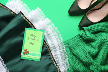 Skirt with high heel shoes, sweater and festive card on green background. St. Patrick's Day...