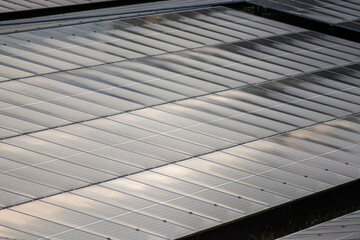 Close-up of large wet industrial solar panels in a field in an industrial zone, after the rain.