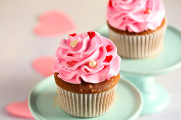 Stand with tasty cupcake for Valentine's Day on light background