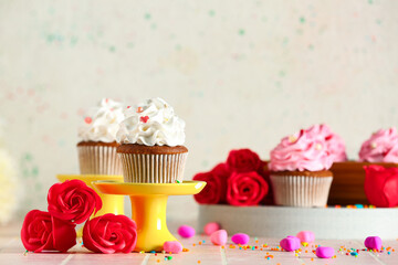 Stand with tasty cupcake, rose flowers and sprinkles for Valentine's Day on table