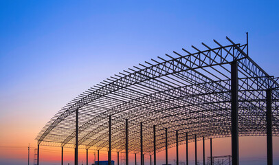 Silhouette of curve metal roof beam framework and columns of large factory building outline...