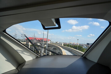 Turn view inside windshield driver cockpit cabin control panel, passenger monorail line turn, autopilot sky train station platform.