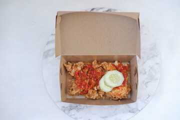 Crispy chicken fried with chili sauce in paper box.