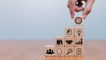 A hand meticulously arranges wooden blocks, symbolizing strategic planning and business development...