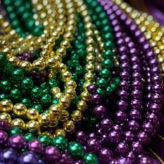 Purple green and gold Mardi Gras beads background 
